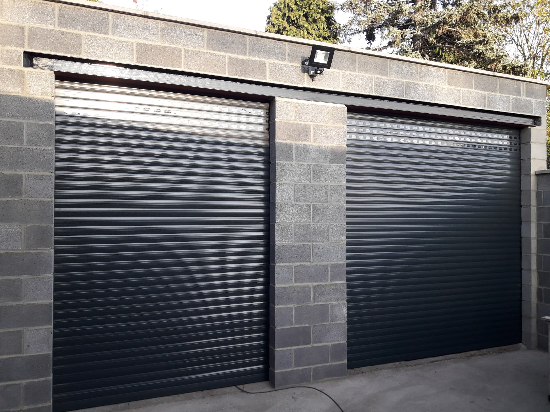 Deux portes de garage enroulables anthracite installées côte à côte