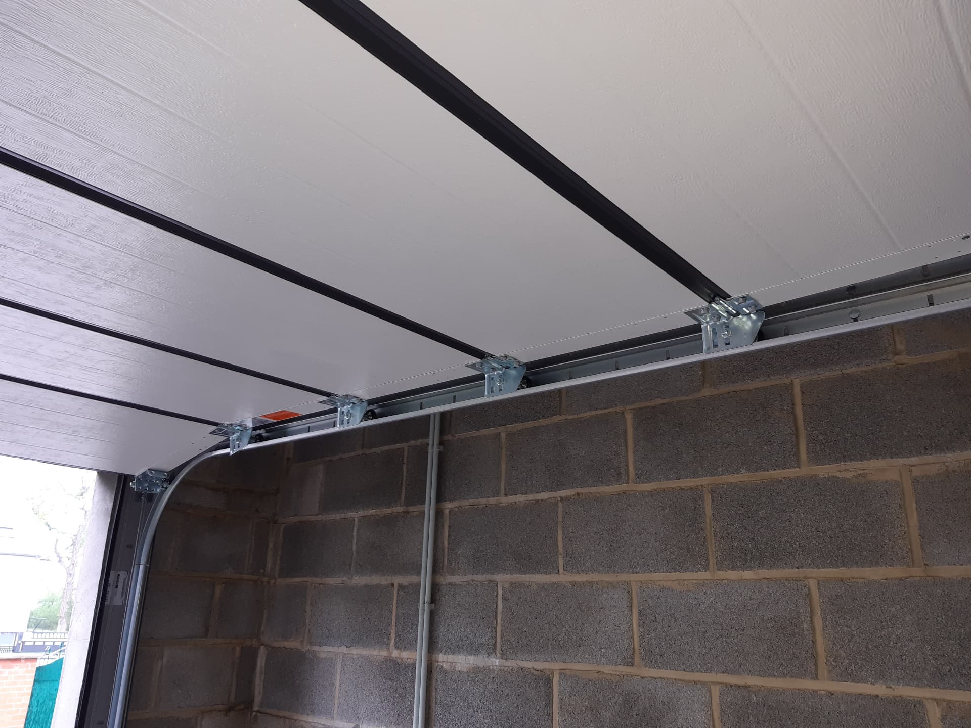 Rails et ferrures plafond d'une porte de garage sectionnelle