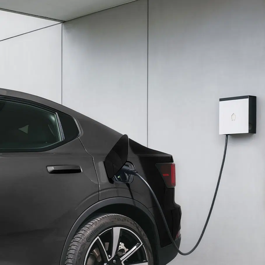 Véhicule électrique en charge sur une borne murale dans un garage