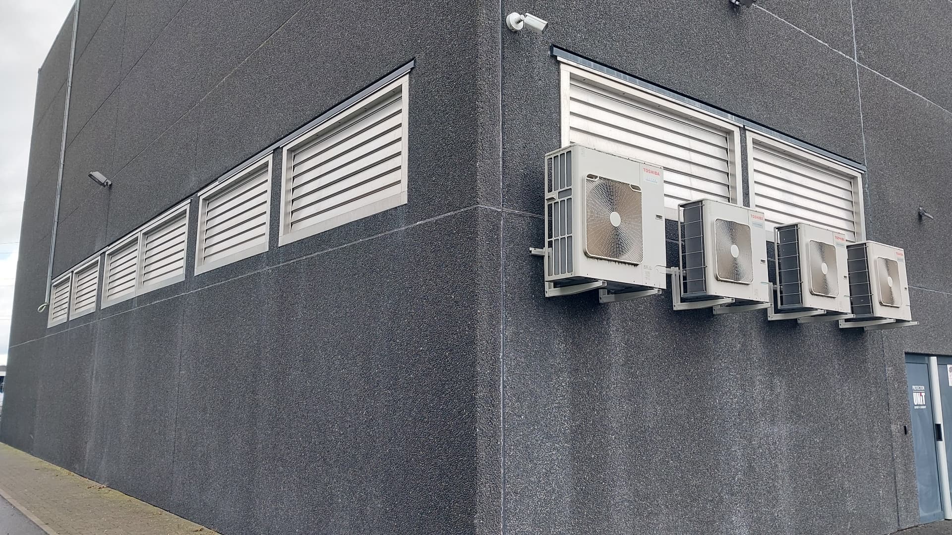 Grilles de ventilation et amenées d'air en façade d'un bâtiment industriel